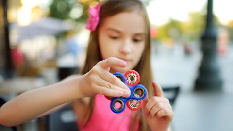elementary school girl holding spinner fidget in focus
