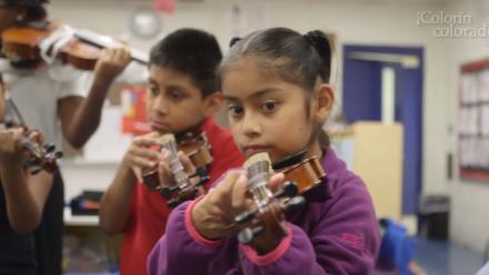 Young Latino/a children at a community school playing the violin