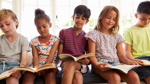 row of elementary kids reading books