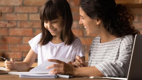 Mother and elementary age daughter working on homework together